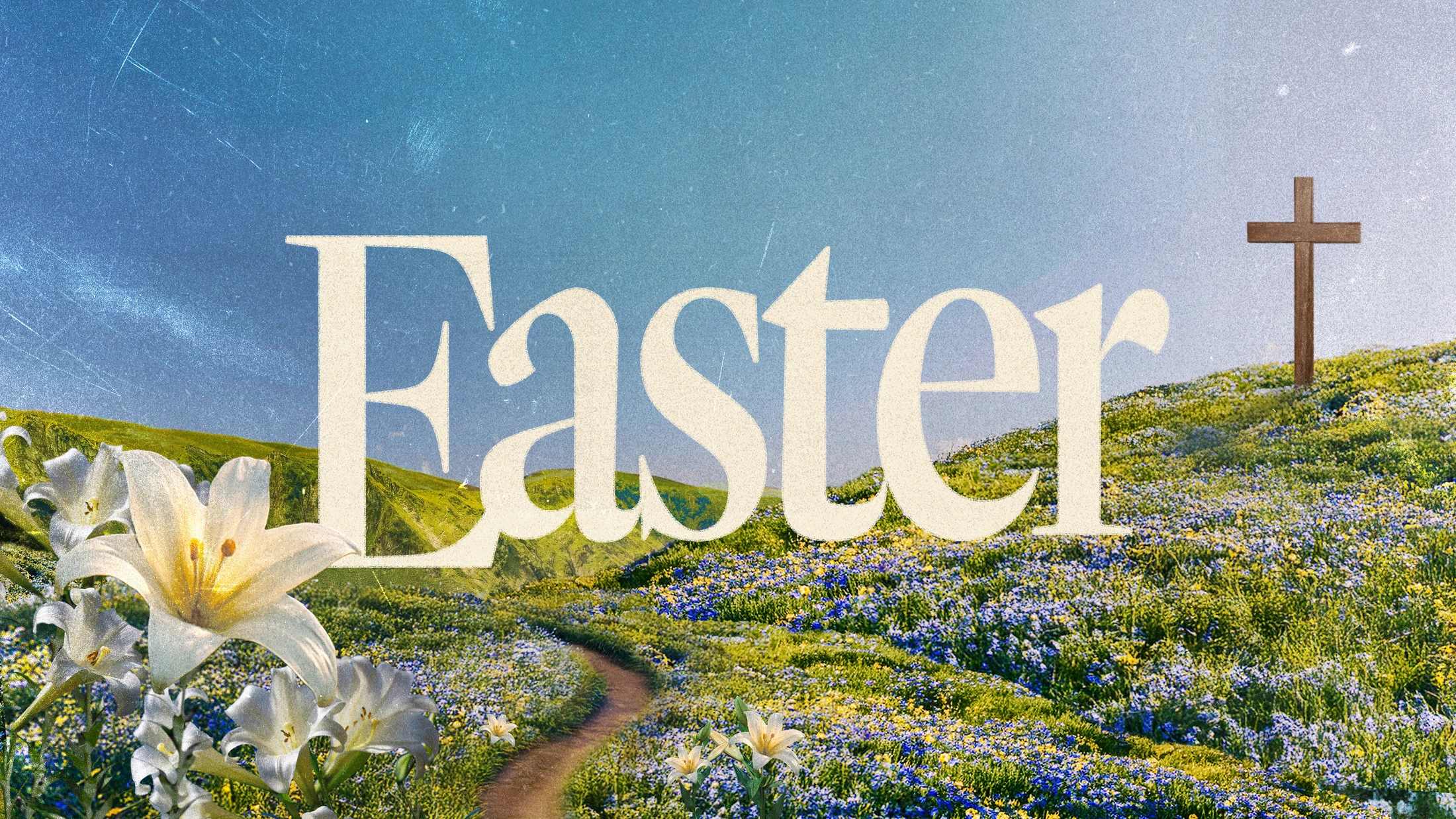 The word Easter over a scenic hillside with wildflowers, a path leading to a wooden cross, and white lilies in the foreground under a blue sky.